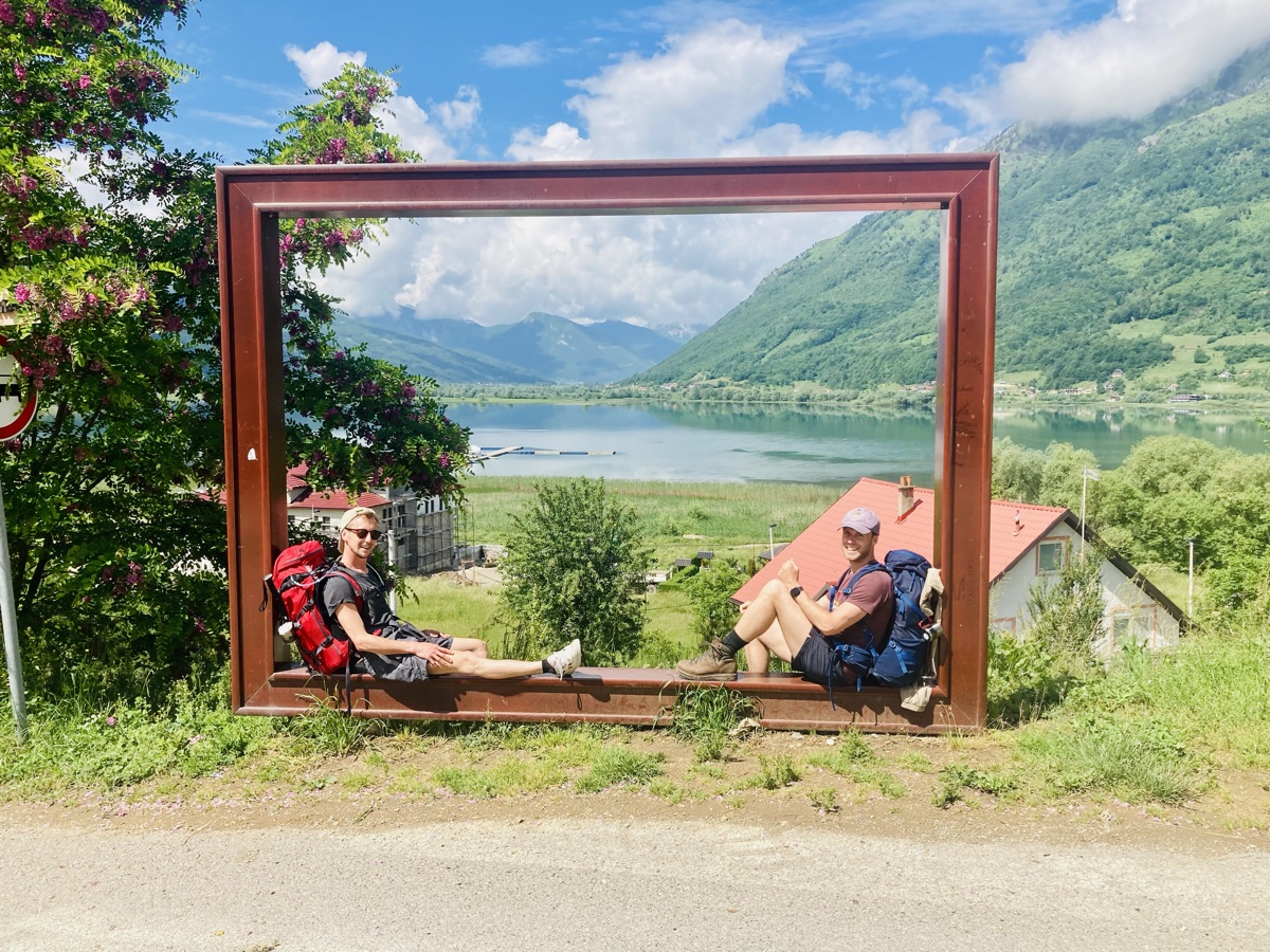 Robin und seine Partnerin mit Wanderrucksäcken vor einem Bergsee